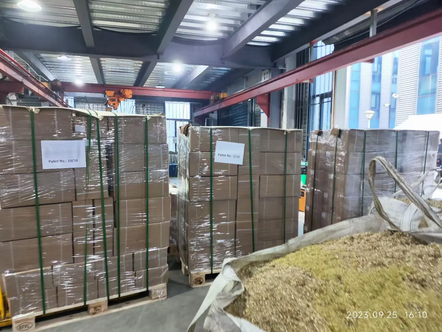 Archived packing record showing multiple numbered export pallets staged in a workshop on 25 September 2023